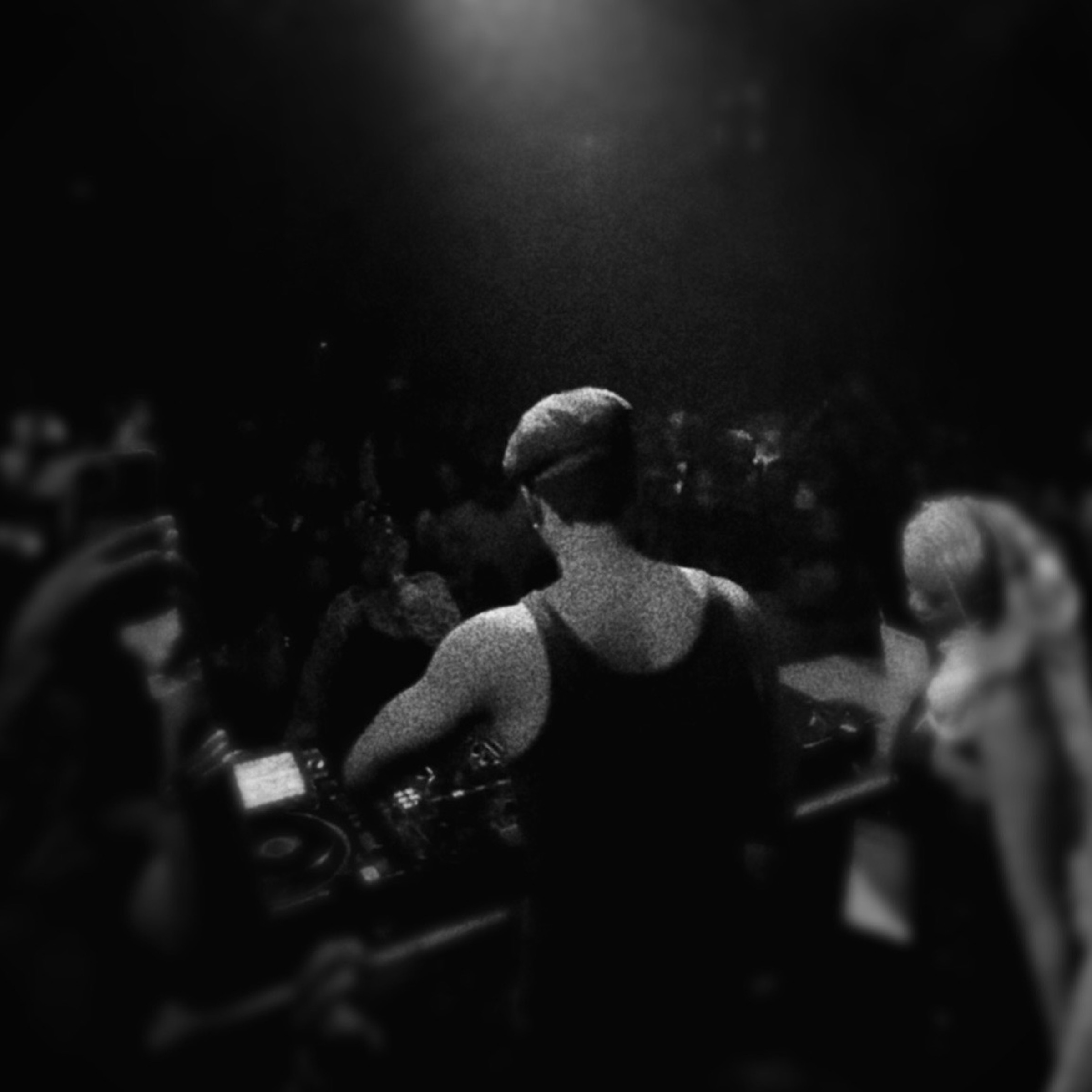 FUNSYDE behind the decks, facing a crowd under a single light
