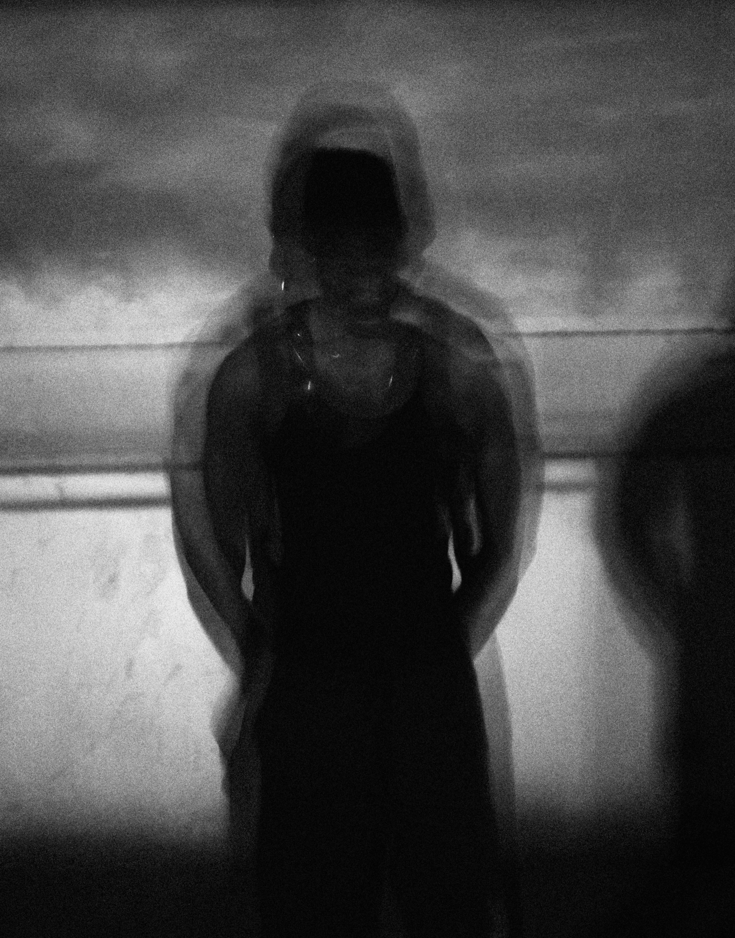 Motion-blurred silhouette of FUNSYDE against a pale wall