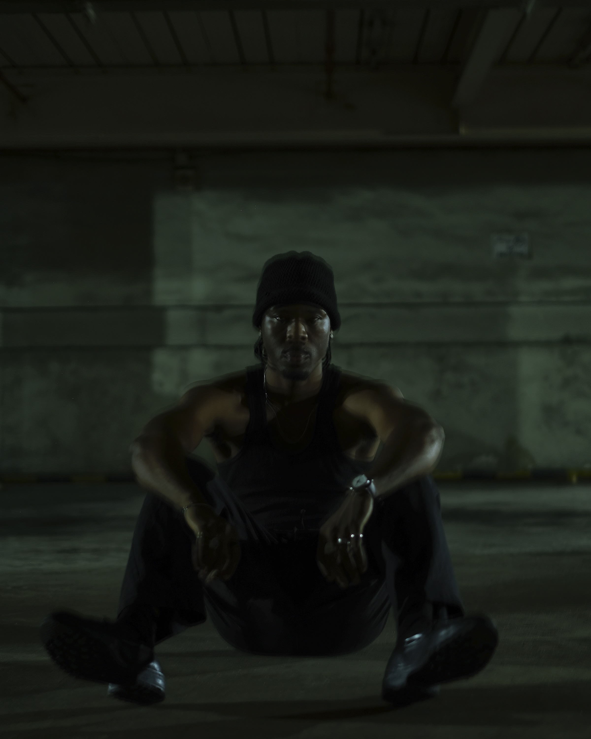 FUNSYDE seated on concrete in green-tinted shadow